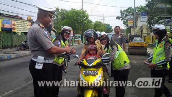 8-3-lis-Petugas Satlantas Polres Sampang, saat memberikan apresiasi pada pengendara tertib di Sampang Kota.